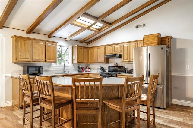 3310 Colton Dr, Springdale, AR 72762 - kitchen with appliances with stainless steel finishes, under cabinet range hood, light wood-style floors, light countertops, and decorative backsplash