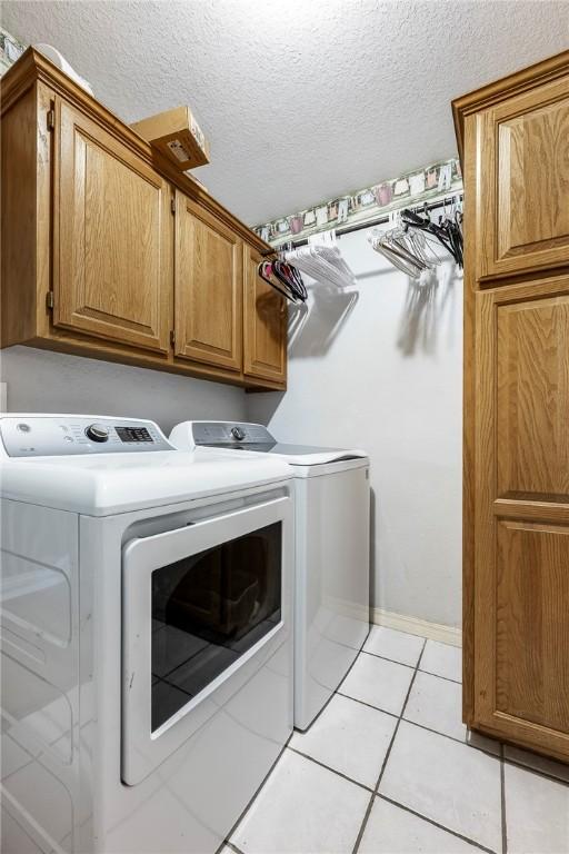 3310 Colton Dr, Springdale, AR 72762 - laundry room featuring independent washer and dryer, cabinet space, light tile patterned flooring, and a textured ceiling