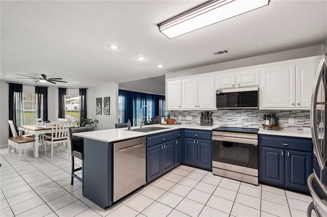 146 Horizon Ln, Alma, AR 72921 - kitchen with appliances with stainless steel finishes, a peninsula, white cabinetry, blue cabinets, and recessed lighting