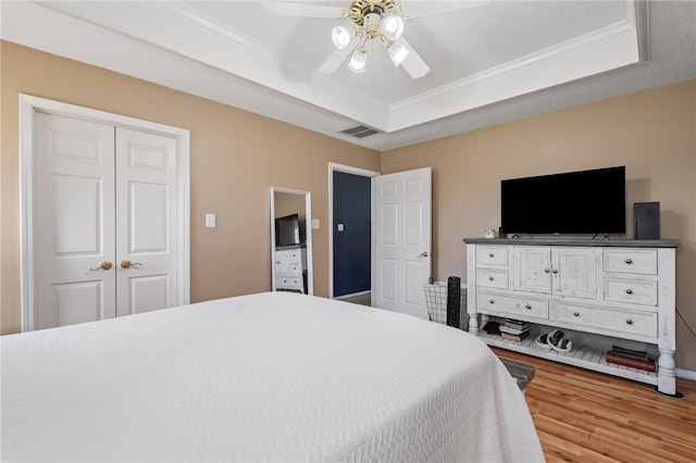 146 Horizon Ln, Alma, AR 72921 - bedroom with light wood finished floors, crown molding, a raised ceiling, and a ceiling fan