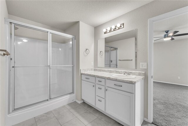 2304 Maplewood Dr, Lowell, AR 72745 - bathroom with vanity, a stall shower, a textured ceiling, a ceiling fan, and tile patterned floors