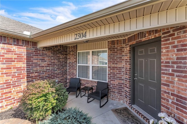 2304 Maplewood Dr, Lowell, AR 72745 - doorway to property with brick siding and a porch