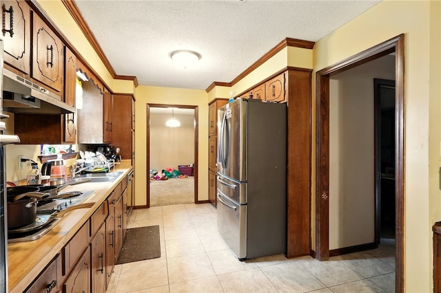 614 Beaconsfield Rd, Sherwood, AR 72120 - kitchen featuring freestanding refrigerator, light countertops, brown cabinets, a textured ceiling, and ornamental molding