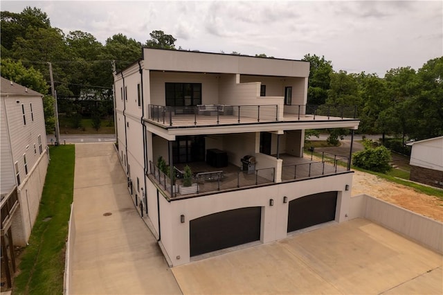 837-839 N Gregg Ave, Fayetteville, AR 72701 - back of house with a balcony, stucco siding, and an attached garage