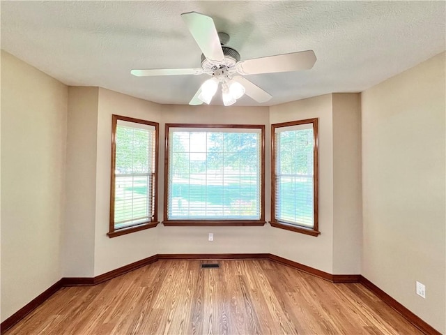 6 Hillcrest Dr, Holiday Island, AR 72631 - empty room with light wood-style floors, ceiling fan, and a textured ceiling