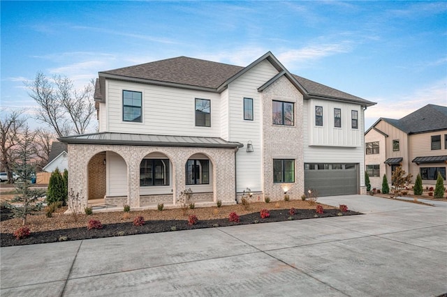 1316 Bella Vista Rd, Bentonville, AR 72712 - view of front of home featuring covered porch, concrete driveway, an attached garage, brick siding, and a standing seam roof