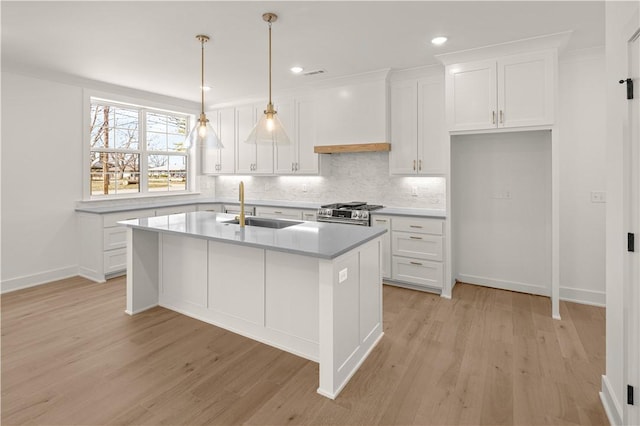 1316 Bella Vista Rd, Bentonville, AR 72712 - kitchen with light wood-style flooring, white cabinetry, decorative backsplash, an island with sink, and recessed lighting