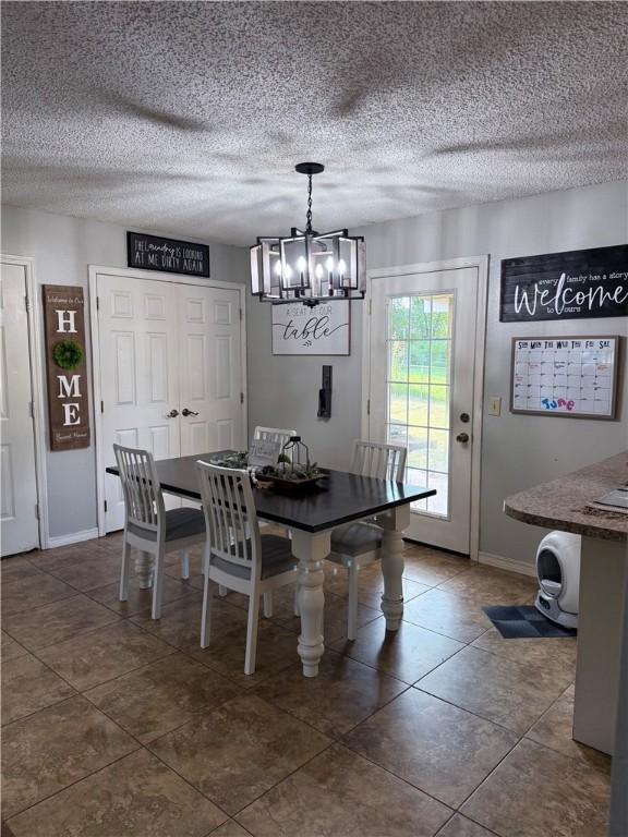 604 W Carver St, Ozark, AR 72949 - dining room featuring a chandelier, dark tile patterned floors, and a textured ceiling