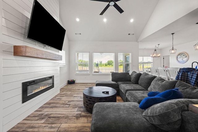 1251 Bootleg Rd, Centerton, AR 72719 - living area with hardwood / wood-style floors, a glass covered fireplace, ceiling fan, a chandelier, and plenty of natural light