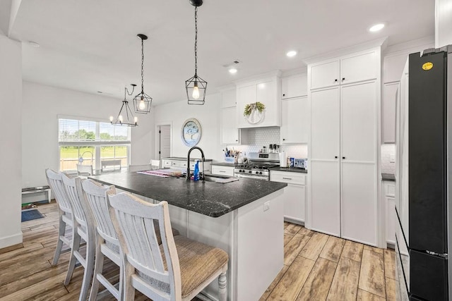 1251 Bootleg Rd, Centerton, AR 72719 - kitchen with freestanding refrigerator, gas stove, light wood-type flooring, white cabinets, and recessed lighting