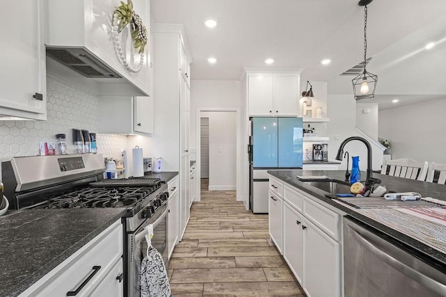 1251 Bootleg Rd, Centerton, AR 72719 - kitchen featuring stainless steel appliances, dark countertops, custom range hood, light wood-style floors, and white cabinets