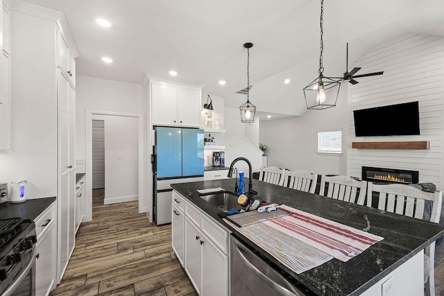 1251 Bootleg Rd, Centerton, AR 72719 - kitchen with appliances with stainless steel finishes, dark wood-type flooring, white cabinets, a fireplace, and recessed lighting