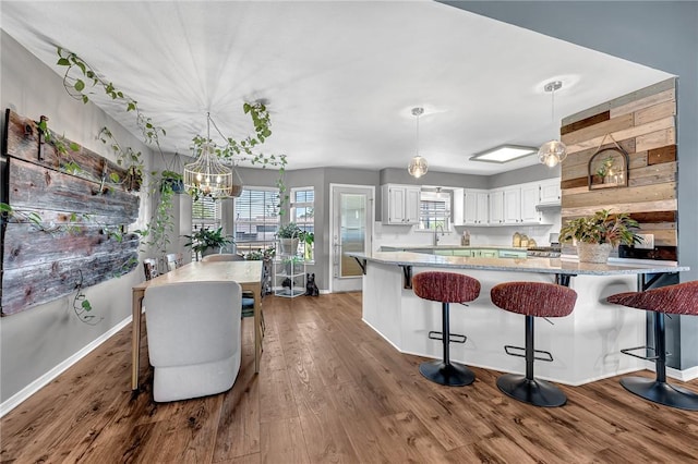1303 W Pine St, Rogers, AR 72758 - kitchen featuring a chandelier, dark wood-style flooring, a peninsula, and white cabinetry