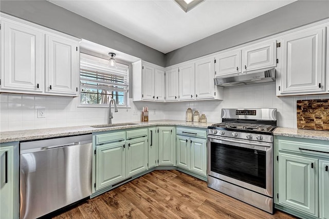 1303 W Pine St, Rogers, AR 72758 - kitchen with appliances with stainless steel finishes, under cabinet range hood, white cabinets, and dark wood-style floors