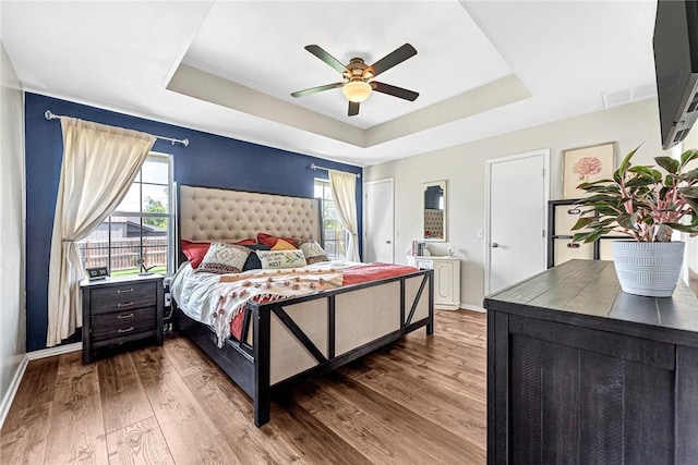1303 W Pine St, Rogers, AR 72758 - bedroom featuring a raised ceiling, multiple windows, wood finished floors, and ceiling fan