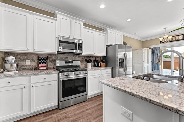 477 Caballo St, Farmington, AR 72730 - kitchen with stainless steel appliances, white cabinetry, a chandelier, backsplash, and crown molding