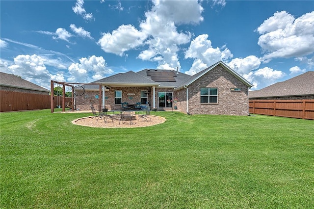 477 Caballo St, Farmington, AR 72730 - rear view of property featuring an outdoor fire pit, solar panels, a fenced backyard, a patio area, and brick siding