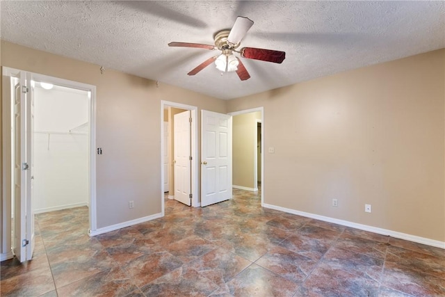 17 Pivot Rock Rd Unit 5, Eureka Springs, AR 72632 - unfurnished bedroom with a spacious closet, stone finish floors, a textured ceiling, a closet, and ceiling fan