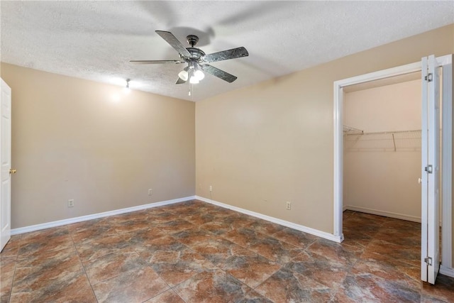 17 Pivot Rock Rd Unit 5, Eureka Springs, AR 72632 - unfurnished bedroom featuring a walk in closet, stone finish floors, a textured ceiling, a closet, and a ceiling fan
