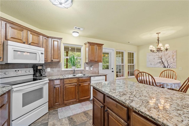 950 Nemett Cir, Pea Ridge, AR 72751 - kitchen with white appliances, a chandelier, tasteful backsplash, decorative light fixtures, and brown cabinets