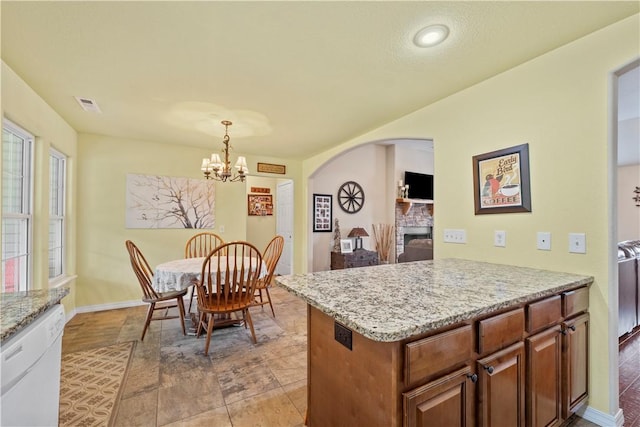 950 Nemett Cir, Pea Ridge, AR 72751 - kitchen featuring dishwasher, a stone fireplace, arched walkways, a chandelier, and light stone countertops