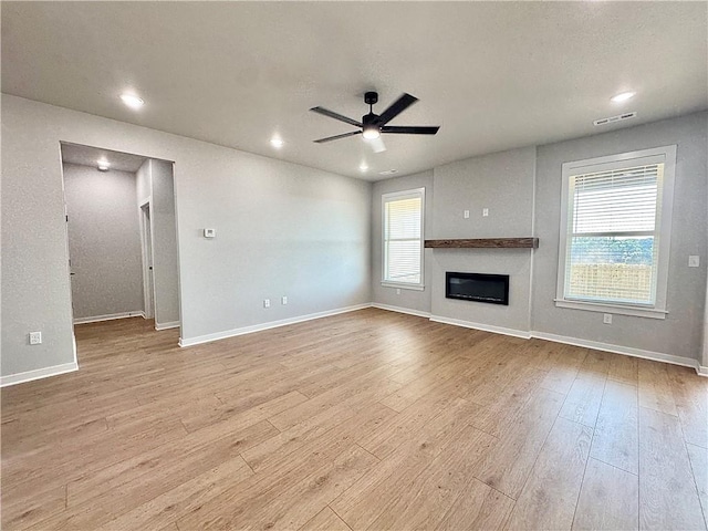 4807 SW Wakanda St, Bentonville, AR 72713 - unfurnished living room featuring a ceiling fan, wood finished floors, a glass covered fireplace, and recessed lighting