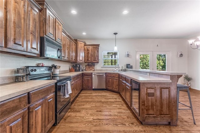 21 Cherhill Dr, Bella Vista, AR 72714 - kitchen featuring black appliances, a kitchen breakfast bar, a peninsula, light countertops, and recessed lighting