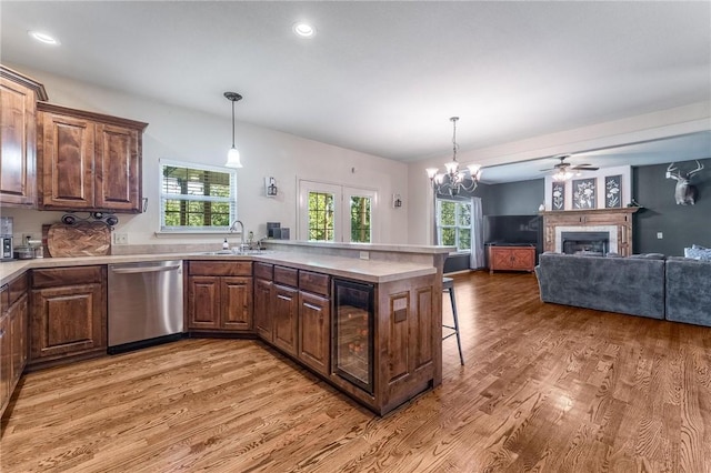 21 Cherhill Dr, Bella Vista, AR 72714 - kitchen featuring stainless steel dishwasher, beverage cooler, light wood-style flooring, a kitchen bar, and a peninsula