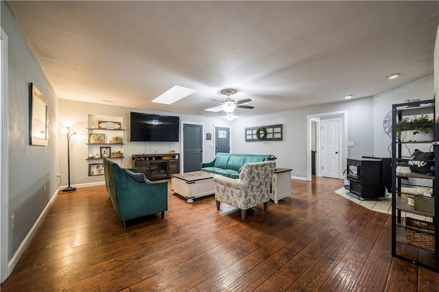 21569 Sibley Rd, Sulphur Springs, AR 72768 - living room with a wood stove, ceiling fan, dark wood-style floors, and a skylight