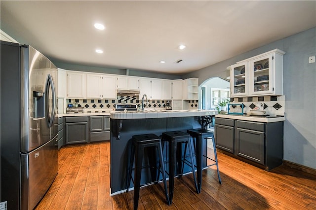 21569 Sibley Rd, Sulphur Springs, AR 72768 - kitchen with stainless steel refrigerator with ice dispenser, arched walkways, backsplash, open shelves, and a center island