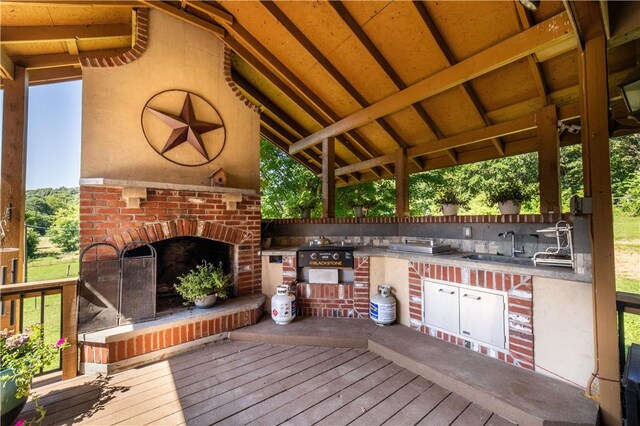 21569 Sibley Rd, Sulphur Springs, AR 72768 - wooden terrace featuring an outdoor brick fireplace and exterior kitchen