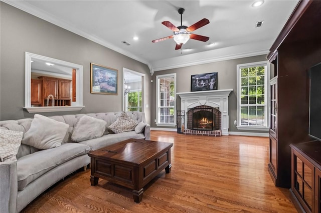 1754 N Hartford Dr, Fayetteville, AR 72701 - living area with crown molding, light wood finished floors, a ceiling fan, recessed lighting, and a brick fireplace