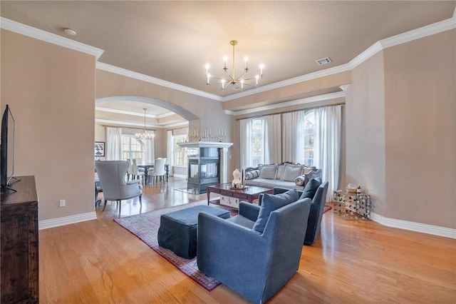 1531 Partridge Run, Bentonville, AR 72713 - living area featuring a chandelier, arched walkways, light wood finished floors, plenty of natural light, and crown molding