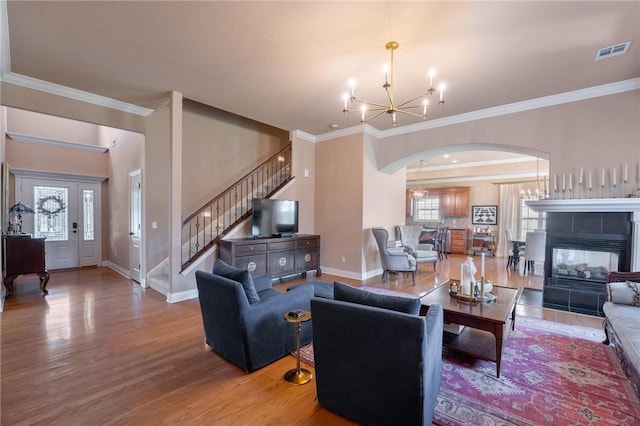 1531 Partridge Run, Bentonville, AR 72713 - living room featuring a chandelier, arched walkways, stairs, wood finished floors, and healthy amount of natural light