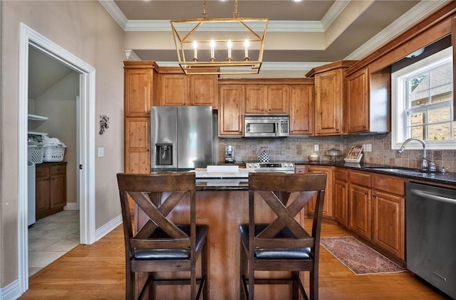 1531 Partridge Run, Bentonville, AR 72713 - kitchen with stainless steel appliances, brown cabinetry, ornamental molding, tasteful backsplash, and light wood finished floors