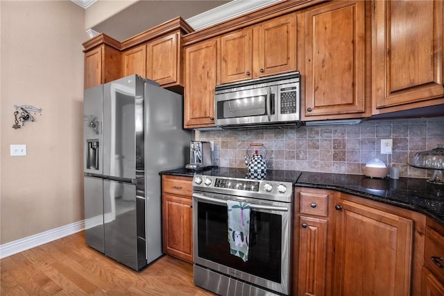 1531 Partridge Run, Bentonville, AR 72713 - kitchen with appliances with stainless steel finishes, brown cabinets, tasteful backsplash, and light wood-style flooring