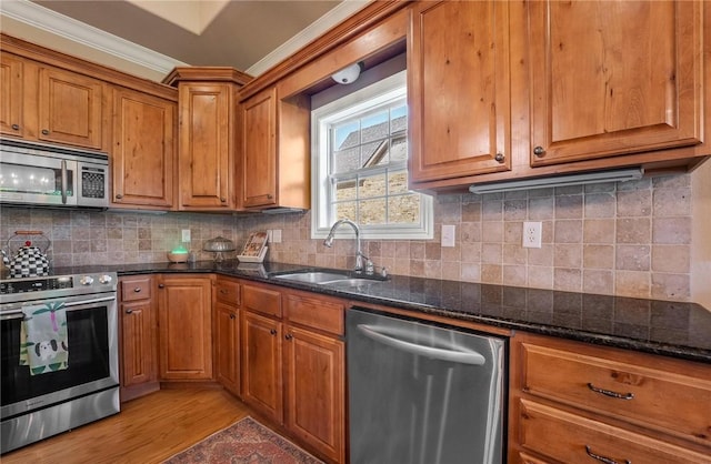 1531 Partridge Run, Bentonville, AR 72713 - kitchen with stainless steel appliances, brown cabinets, crown molding, light wood finished floors, and dark stone countertops