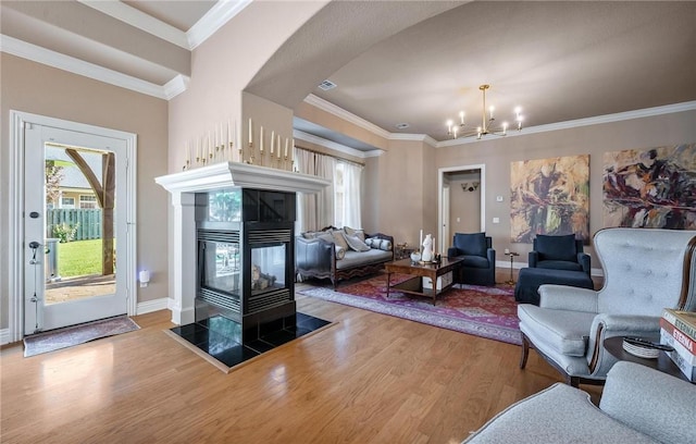 1531 Partridge Run, Bentonville, AR 72713 - living room featuring wood finished floors, a chandelier, ornamental molding, and a tiled fireplace