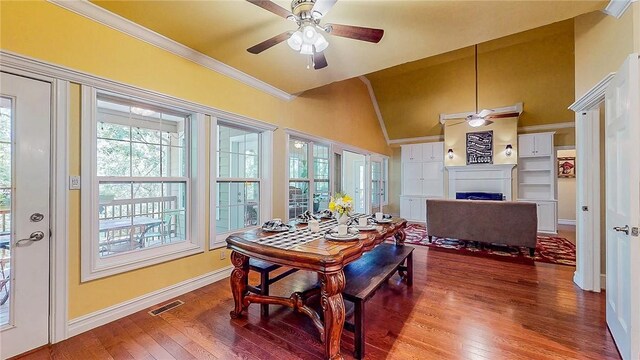 19641 Conestoga Rd, Elkins, AR 72727 - dining space featuring a ceiling fan, a fireplace, wood finished floors, ornamental molding, and lofted ceiling