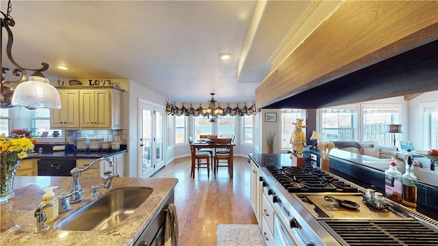 8271 S Lakeshore Dr, Rogers, AR 72756 - kitchen with premium range hood, cream cabinetry, light wood-type flooring, recessed lighting, and hanging light fixtures