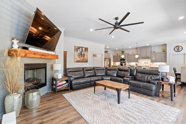 1575 Lake Estates Dr, Springdale, AR 72762 - living room featuring light wood finished floors, ceiling fan, a large fireplace, and recessed lighting