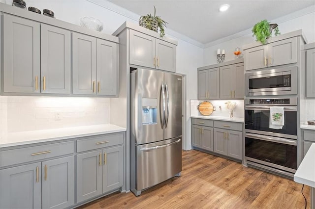 1575 Lake Estates Dr, Springdale, AR 72762 - kitchen featuring stainless steel appliances, gray cabinets, decorative backsplash, light countertops, and ornamental molding