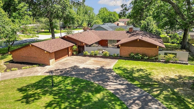 2001 Pin Oak Dr, Springdale, AR 72762 - mid-century modern home with brick siding, concrete driveway, a garage, and roof with shingles