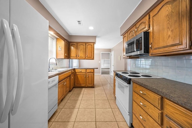 2001 Pin Oak Dr, Springdale, AR 72762 - kitchen with white appliances, brown cabinets, backsplash, light tile patterned floors, and dark countertops