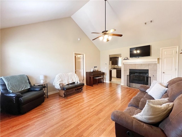 1459 Frisco Track Trce, Elkins, AR 72727 - living area with a ceiling fan, high vaulted ceiling, light wood-type flooring, and a tile fireplace
