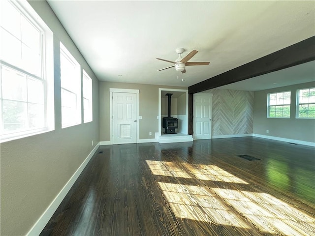 22198 E Ar 12th Hwy, Rogers, AR 72756 - unfurnished living room featuring a wood stove, dark wood finished floors, and a ceiling fan