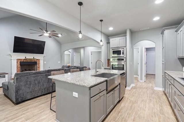 11403 Effie Way, Farmington, AR 72730 - kitchen with gray cabinetry, arched walkways, appliances with stainless steel finishes, ceiling fan, and light wood-style floors