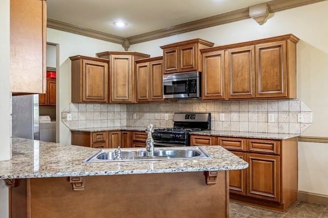 3004 N 16th St, Rogers, AR 72756 - kitchen featuring appliances with stainless steel finishes, washer / clothes dryer, crown molding, brown cabinetry, and tasteful backsplash