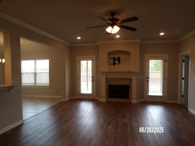 298 S Benchmark Ln, Fayetteville, AR 72704 - unfurnished living room featuring a tiled fireplace, plenty of natural light, a ceiling fan, crown molding, and dark wood-style flooring