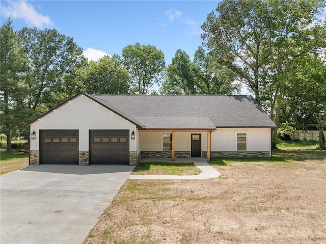 1348 Columbine Cv, Harrison, AR 72601 - modern farmhouse featuring stone siding, concrete driveway, an attached garage, covered porch, and a front yard